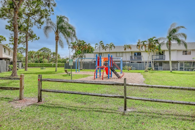 community jungle gym featuring fence and a yard