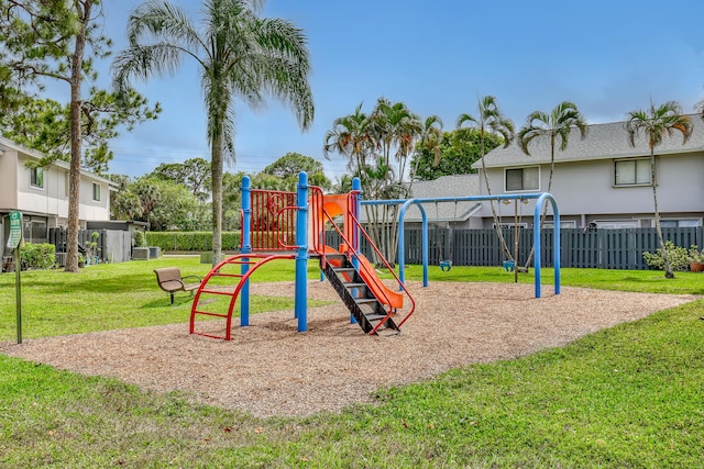 communal playground featuring fence and a yard