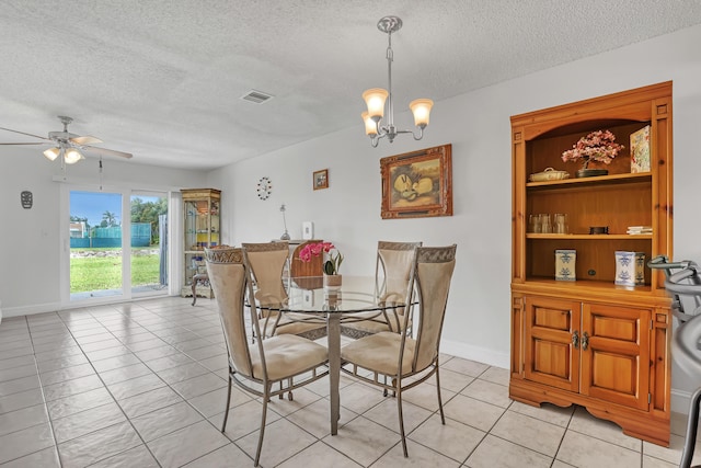 dining room with ceiling fan with notable chandelier, visible vents, light tile patterned floors, and a textured ceiling