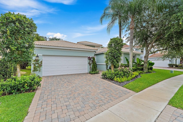 149 Sedona Way, Palm Beach Gardens, FL 33418 - mediterranean / spanish house featuring a garage, a tile roof, stucco siding, driveway, and a front lawn
