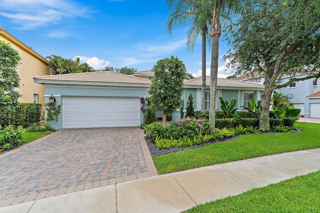 149 Sedona Way, Palm Beach Gardens, FL 33418 - mediterranean / spanish house featuring stucco siding, a tiled roof, decorative driveway, a garage, and a front lawn