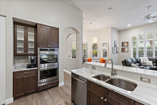 149 Sedona Way, Palm Beach Gardens, FL 33418 - kitchen with stainless steel appliances, a sink, dark brown cabinets, a ceiling fan, and glass insert cabinets
