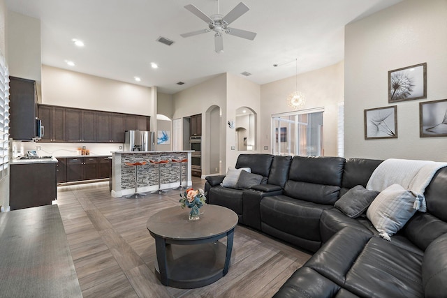 149 Sedona Way, Palm Beach Gardens, FL 33418 - living area with arched walkways, a ceiling fan, a high ceiling, light wood-style flooring, and recessed lighting