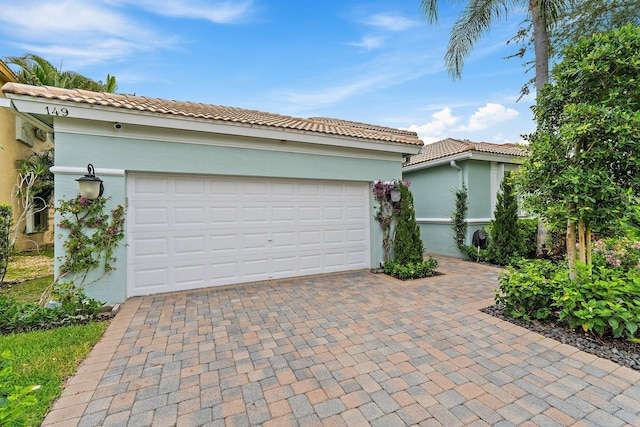149 Sedona Way, Palm Beach Gardens, FL 33418 - mediterranean / spanish home featuring driveway, stucco siding, a tiled roof, and a garage