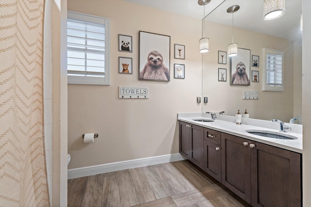 149 Sedona Way, Palm Beach Gardens, FL 33418 - full bathroom featuring toilet, double vanity, baseboards, and wood finished floors