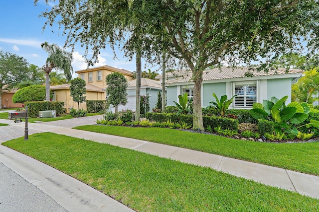 149 Sedona Way, Palm Beach Gardens, FL 33418 - view of front facade with decorative driveway, stucco siding, a front yard, a tile roof, and an attached garage