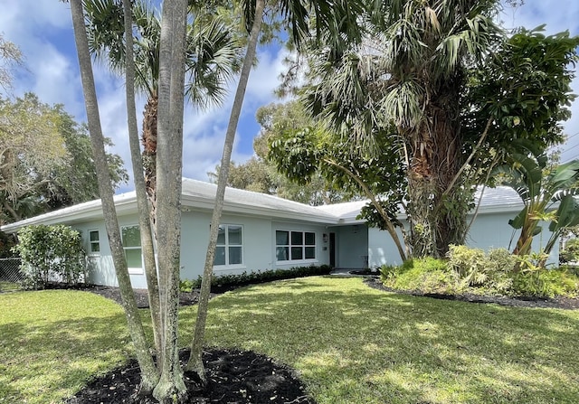 exterior space with stucco siding and a front yard