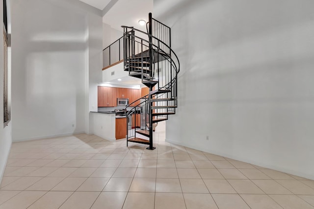 801 S Olive Ave Unit 127, West Palm Beach, FL 33401 - staircase with tile patterned floors, baseboards, visible vents, and a towering ceiling