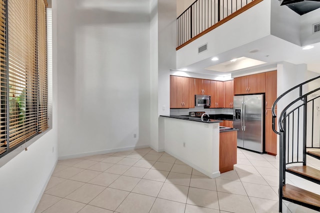 801 S Olive Ave Unit 127, West Palm Beach, FL 33401 - kitchen featuring appliances with stainless steel finishes, dark countertops, baseboards, visible vents, and a towering ceiling