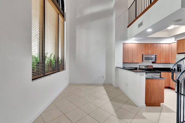 801 S Olive Ave Unit 127, West Palm Beach, FL 33401 - kitchen with visible vents, a peninsula, baseboards, dark countertops, and appliances with stainless steel finishes