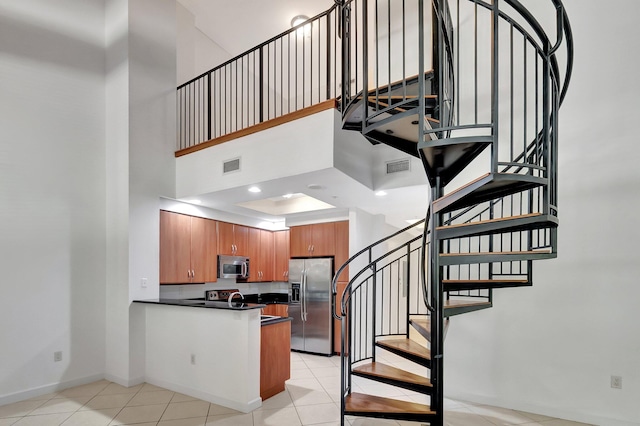 801 S Olive Ave Unit 127, West Palm Beach, FL 33401 - stairs featuring visible vents, tile patterned flooring, and a towering ceiling