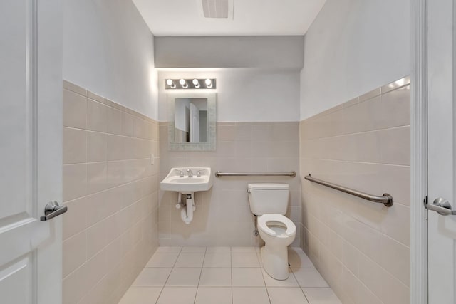 801 S Olive Ave Unit 127, West Palm Beach, FL 33401 - half bath featuring tile patterned floors, wainscoting, tile walls, toilet, and visible vents