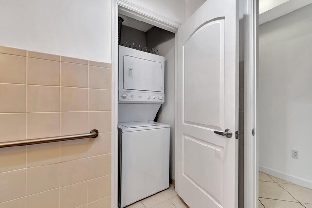 801 S Olive Ave Unit 127, West Palm Beach, FL 33401 - clothes washing area with light tile patterned floors, stacked washer and clothes dryer, and laundry area