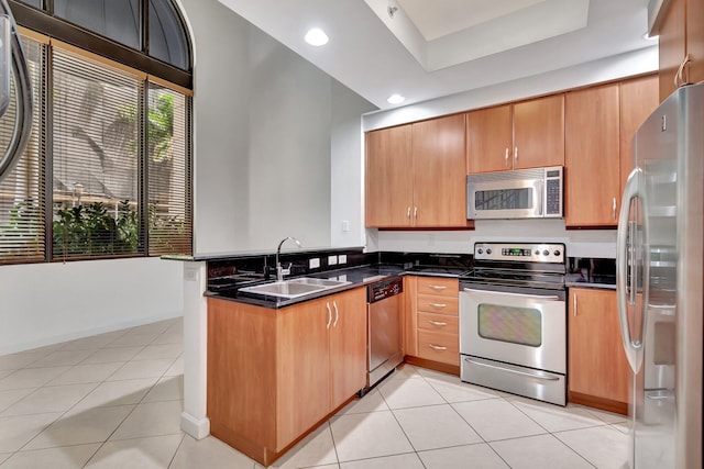 801 S Olive Ave Unit 127, West Palm Beach, FL 33401 - kitchen with a sink, stainless steel appliances, light tile patterned floors, a peninsula, and dark countertops