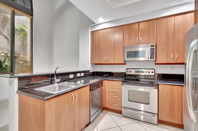 801 S Olive Ave Unit 127, West Palm Beach, FL 33401 - kitchen featuring light tile patterned floors, stainless steel appliances, a peninsula, and a sink