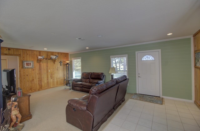 living area with baseboards, ornamental molding, visible vents, and wood walls