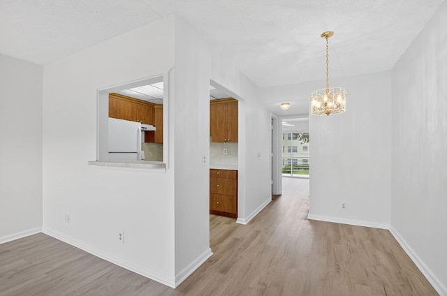 63 Dorset Unit B, Boca Raton, FL 33434 - unfurnished dining area featuring light wood-style flooring and a chandelier