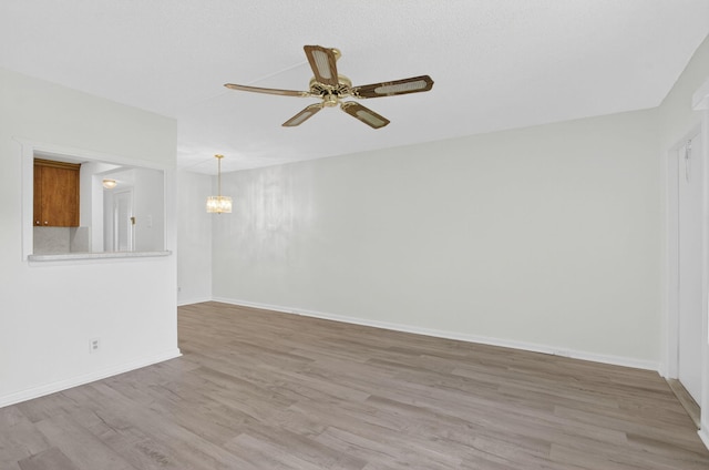 63 Dorset Unit B, Boca Raton, FL 33434 - spare room featuring a chandelier, light wood-style floors, and a ceiling fan