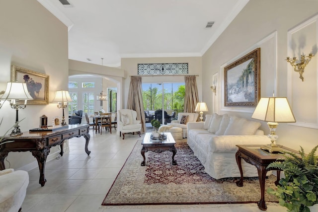 living room with light tile patterned flooring, crown molding, arched walkways, and a healthy amount of sunlight