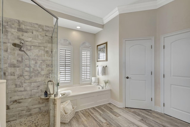 bathroom with wood finished floors, a stall shower, crown molding, and a bath
