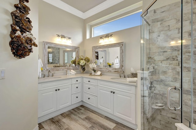 full bath with a shower stall, double vanity, ornamental molding, and a sink