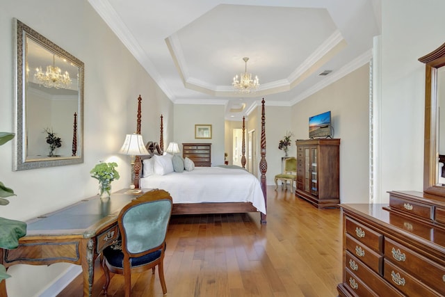bedroom featuring an inviting chandelier, hardwood / wood-style floors, ornamental molding, a raised ceiling, and visible vents