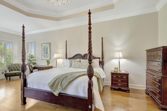 bedroom with a raised ceiling, light wood finished floors, a chandelier, baseboards, and ornamental molding