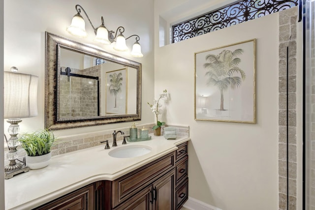 full bathroom featuring tiled shower and vanity