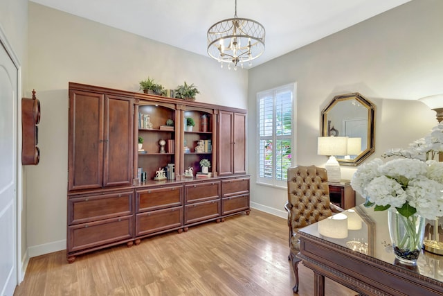 office with light wood finished floors, baseboards, and a chandelier