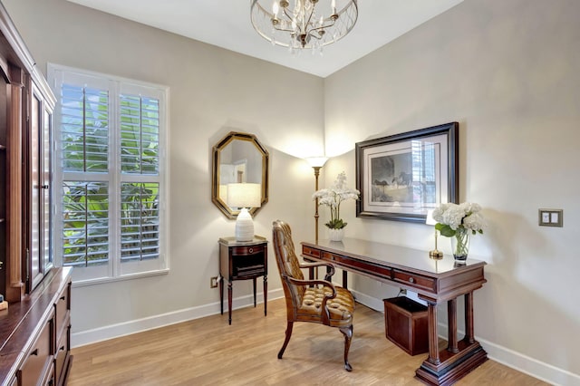 office featuring an inviting chandelier, baseboards, a healthy amount of sunlight, and light wood-type flooring