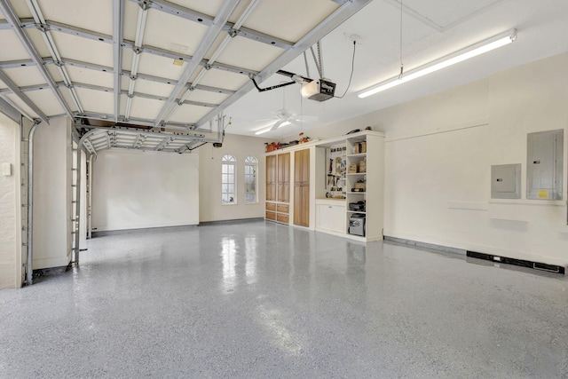 garage featuring baseboards, a garage door opener, and electric panel