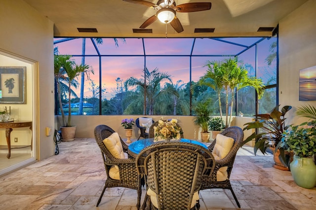 sunroom with outdoor dining area and ceiling fan