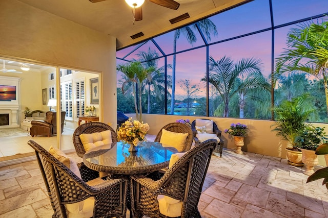 view of patio with an outdoor hangout area, outdoor dining space, glass enclosure, visible vents, and a ceiling fan