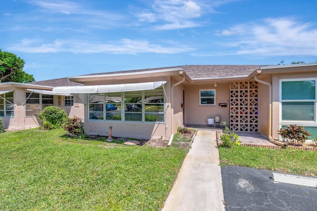 1245 High Point Pl S Unit C, Delray Beach, FL 33445 - view of front facade featuring roof with shingles, stucco siding, and a front yard