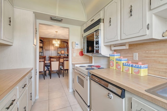 1245 High Point Pl S Unit C, Delray Beach, FL 33445 - kitchen with electric range, an inviting chandelier, light tile patterned floors, backsplash, and visible vents