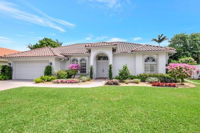 1325 E Barwick Ranch Cir, Delray Beach, FL 33445 - mediterranean / spanish home featuring decorative driveway, a front yard, a garage, a tiled roof, and fence
