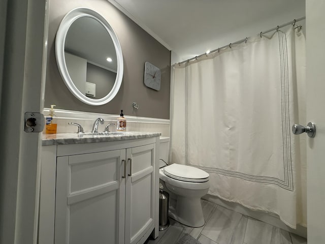 340 Normandy H, Delray Beach, FL 33484 - bathroom featuring toilet, vanity, crown molding, and a wainscoted wall