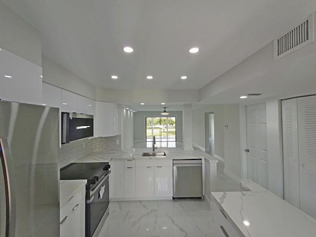 kitchen with a sink, visible vents, recessed lighting, modern cabinets, and appliances with stainless steel finishes