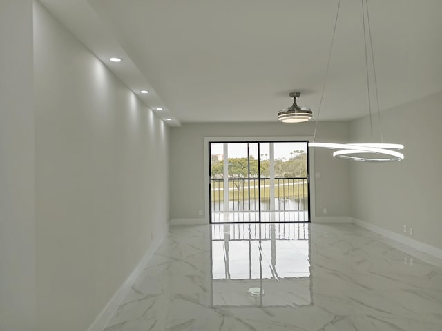 unfurnished room featuring baseboards, recessed lighting, marble finish floor, and a water view