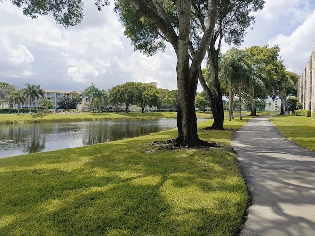 view of property's community with a yard and a water view