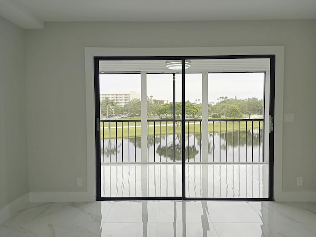 entryway with marble finish floor, baseboards, and a water view