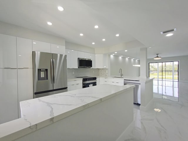 kitchen featuring stainless steel appliances, tasteful backsplash, recessed lighting, white cabinetry, and modern cabinets