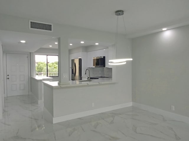 kitchen with stainless steel appliances, visible vents, modern cabinets, baseboards, and white cabinetry
