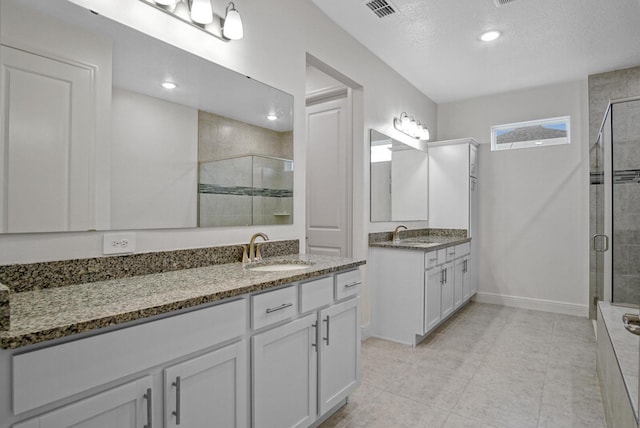 bathroom featuring visible vents, a sink, and a shower stall