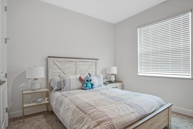 bedroom with baseboards and carpet