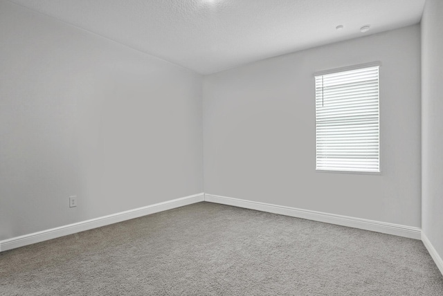 carpeted spare room with baseboards