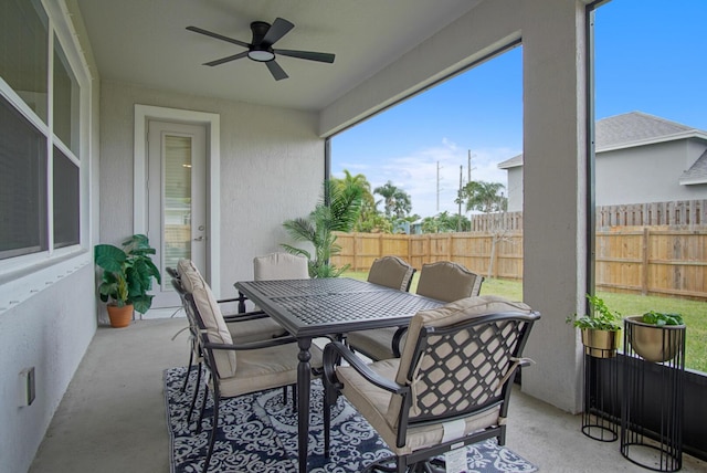 sunroom / solarium featuring a ceiling fan and outdoor dining area