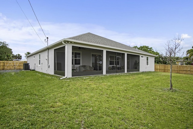 back of house with stucco siding, a sunroom, fence private yard, central AC unit, and a lawn