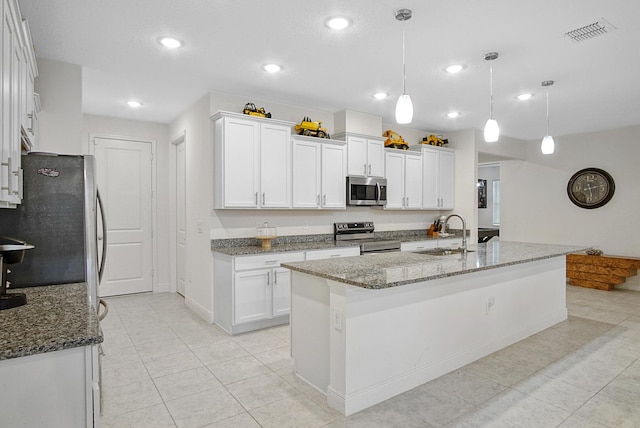 kitchen featuring stone counters, a sink, appliances with stainless steel finishes, visible vents, and white cabinets
