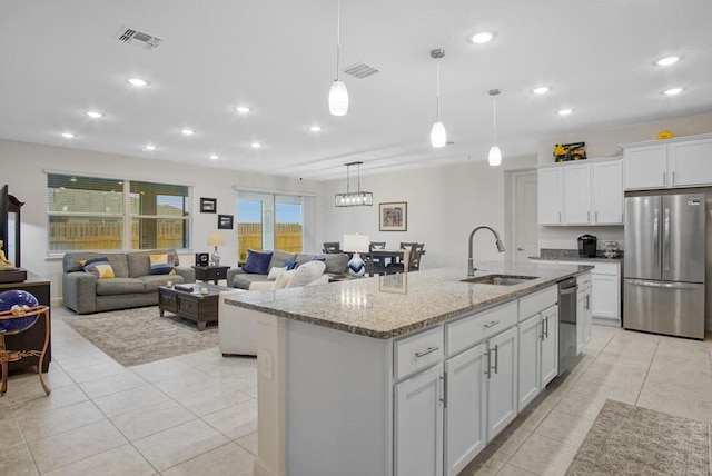 kitchen featuring a sink, visible vents, light stone countertops, and appliances with stainless steel finishes